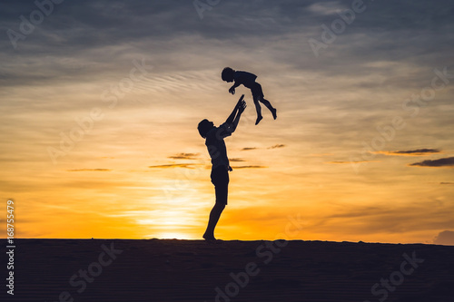 Father and son at the red desert at dawn. Traveling with children concept