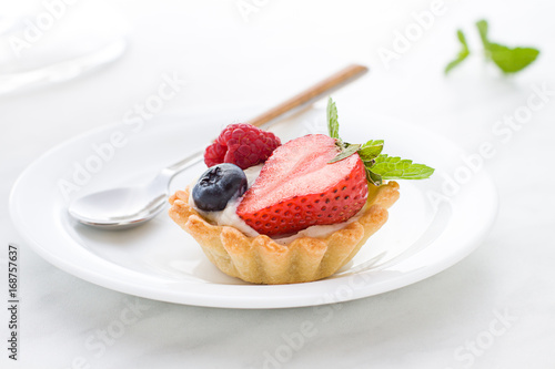 Mini tarts on the plate close up. Homemade dessert with delicious catalonian traditional cream and fresh berries