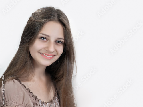 Beautiful girl smiling. Clean skin, natural beauty. Portrait, white background. Long brown hair © kozorog