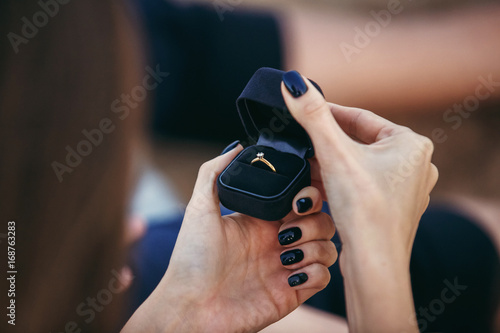 close up woman hands opening engagment ring box