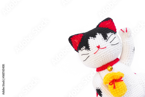 Photography Japanese Lucky Cat Maneki Neko isolated on white background, the crochet cat doll is emerging on the right corner to leave middle area for copy space and your text