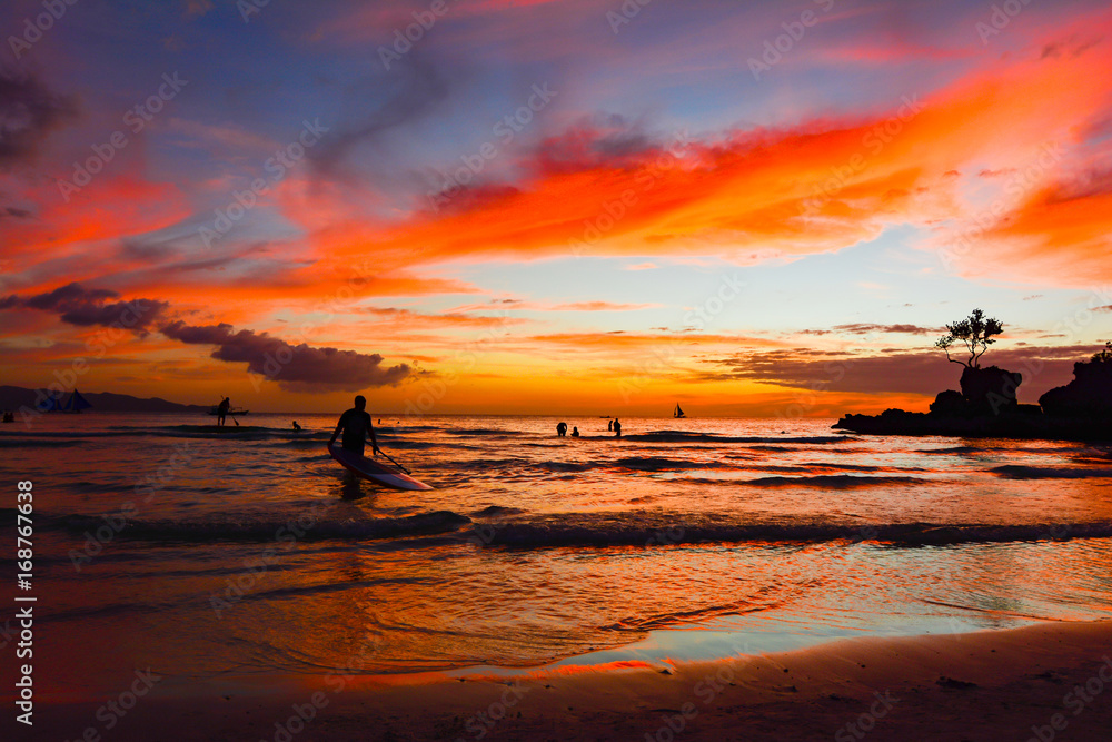 Colors at sunset in the ocean with wooden boats in the sea of the tropical island of Boracay in the Philippines
