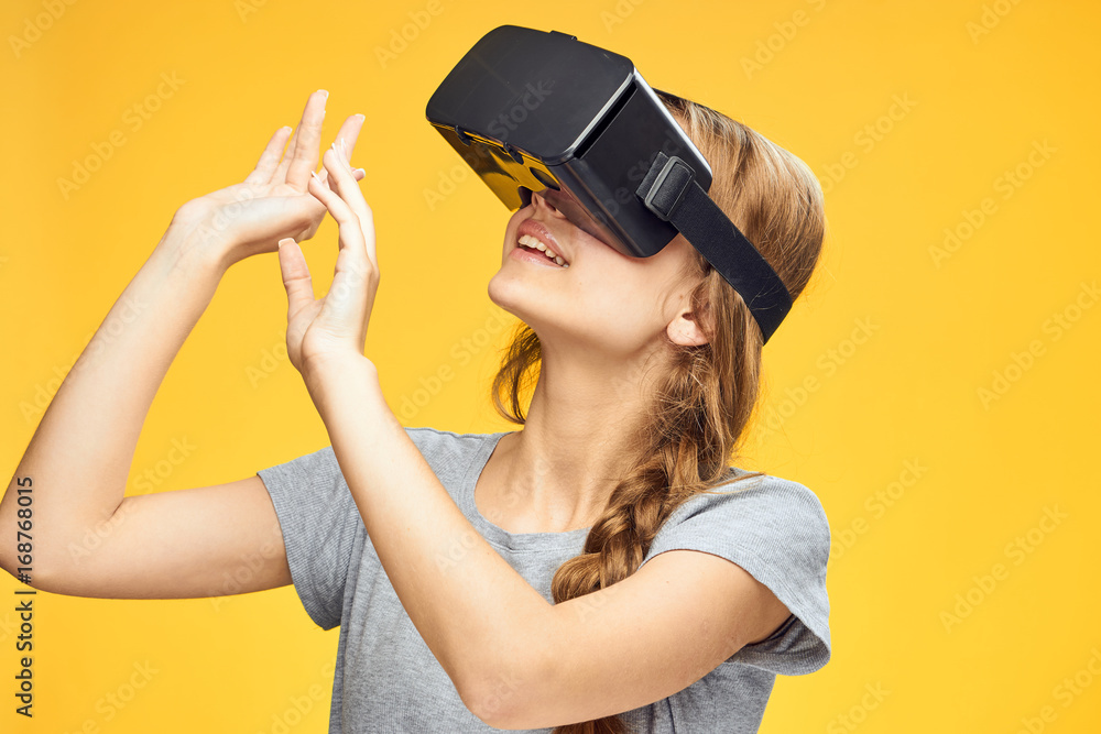 Beautiful young woman on a yellow background with virtual reality glasses Beautiful young woman on a yellow background with virtual reality glasses