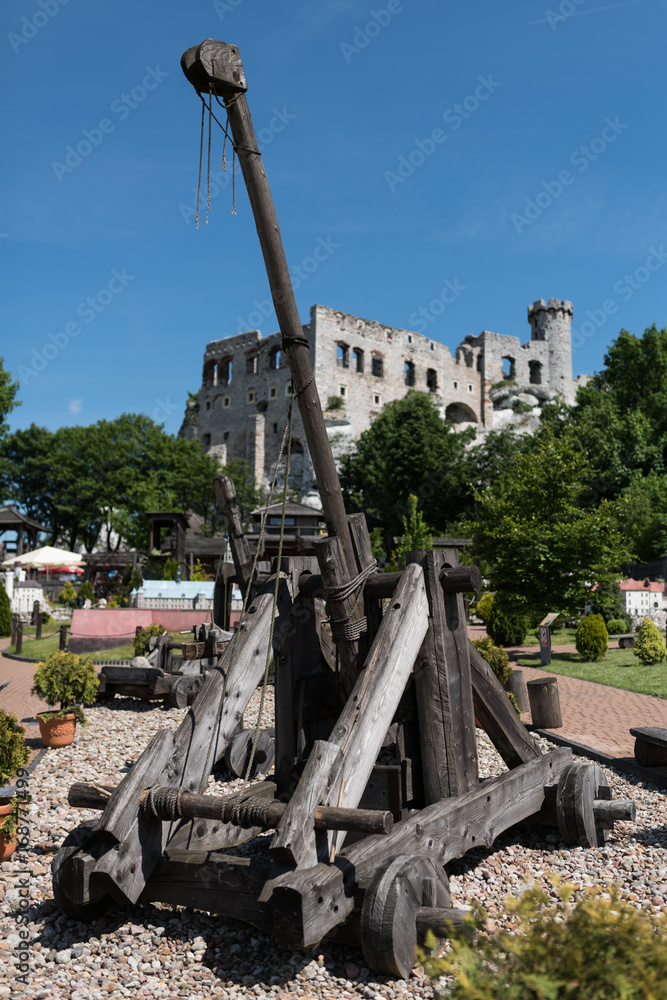 Medieval catapult made entirely of wood, Old castle Ogrodzieniec in the background Medieval catapult made entirely of wood, Old castle Ogrodzieniec in the background