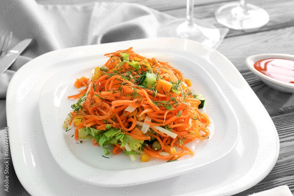 Plate with delicious spicy carrot spaghetti on table Plate with delicious spicy carrot spaghetti on table