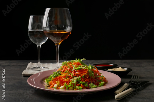 Plate with delicious spicy carrot spaghetti on table