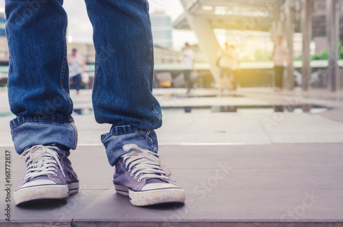 close up legs men casual wearing jeans and shoes stand on concrete stair. waiting, start and ready concept.