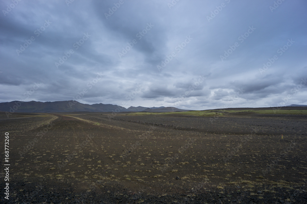 Iceland - Wide scraggy lava landscape and mountain chain Iceland - Wide scraggy lava landscape and mountain chain