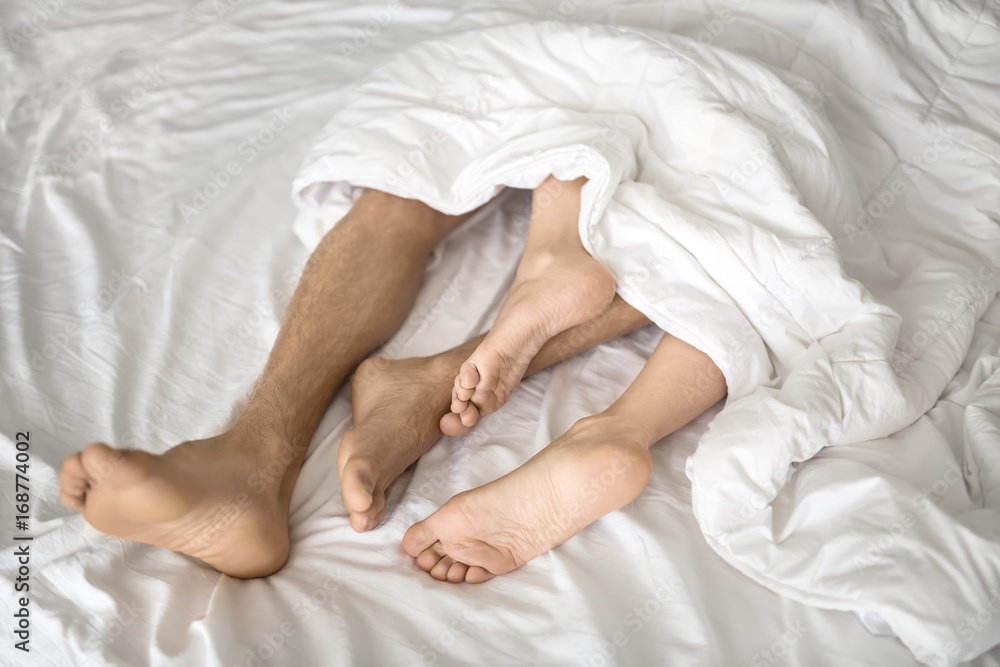 Legs of lovers under blanket Legs of lovers under blanket