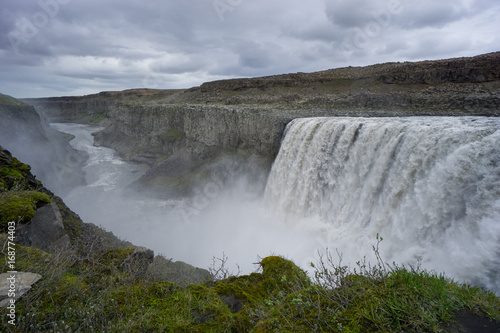 Iceland - Green moss at majestic detifoss waterfall with canyon and river