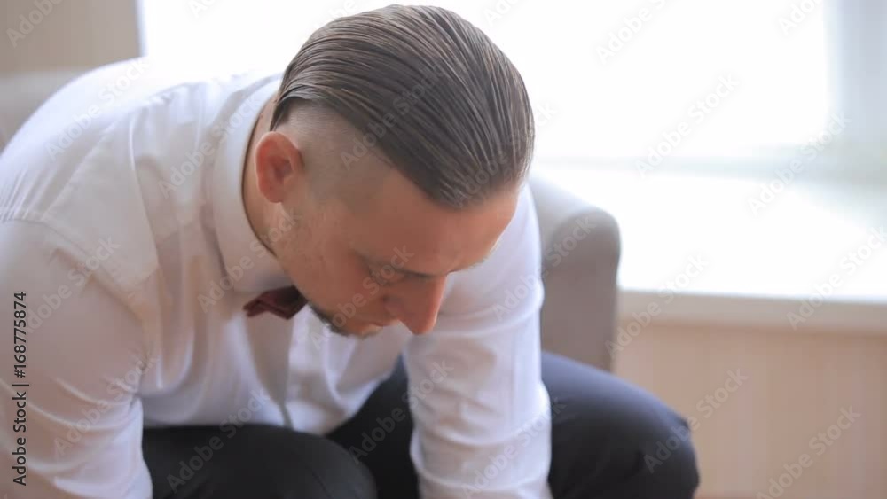 Man puts on shoes. man puts on black new fashion shoes and tie shoelaces. close-up Man puts on shoes. man puts on black new fashion shoes and tie shoelaces. close-up