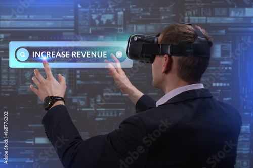 Business, Technology, Internet and network concept. Young businessman working on a virtual screen of the future and sees the inscription: Increase revenue
