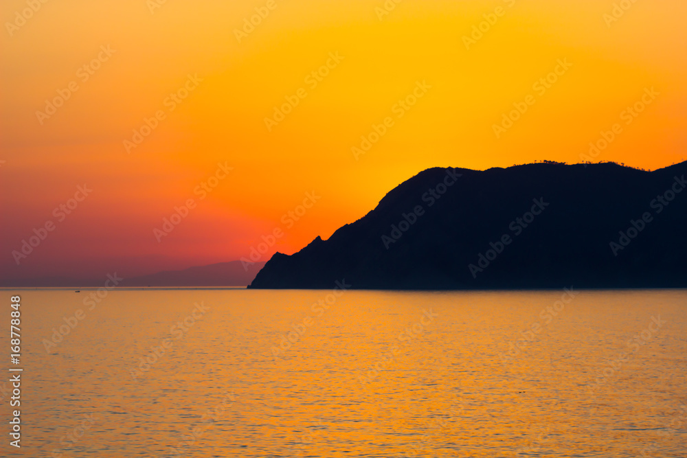 Natural Sunset, Sunrise over sea, mountain Bright Dramatic Sky And Dark Ground. Countryside Landscape Under Scenic Colorful Sky At Sunset Dawn Sunrise. Sun Over Skyline, Horizon. Warm Colours.