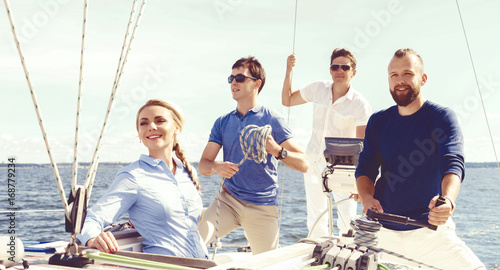 Group of friends traveling on a yacht and enjoying a good summer day. Vacation, holiday, summertime concept.