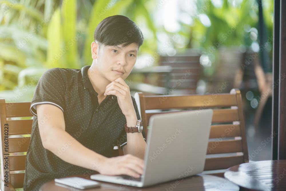 Businessman working laptop for new architectural project, sitting at table in cafe and uses laptop.Nearby is smartphone. Generic design notebook on the table. Freelancer working outside office Businessman working laptop for new architectural project, sitting at table in cafe and uses laptop.Nearby is smartphone. Generic design notebook on the table. Freelancer working outside office