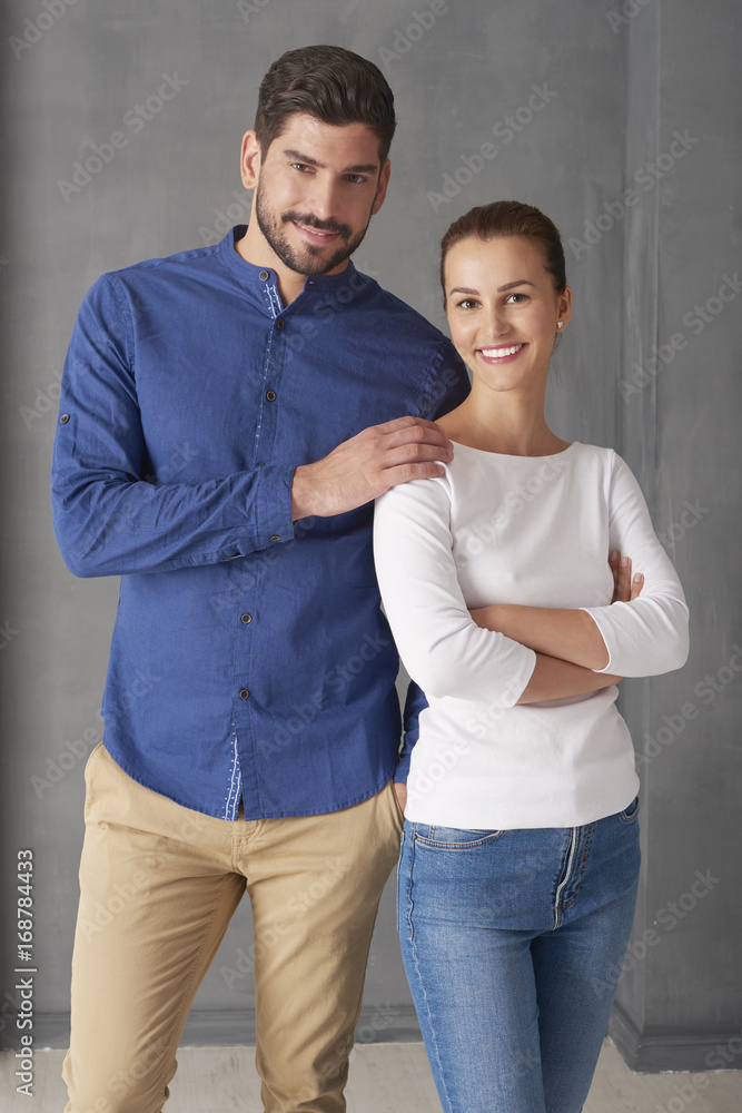 Enjoy every moment together. Studio portrait of a loving young couple embracing each other while standing at grey wall with copy space. 