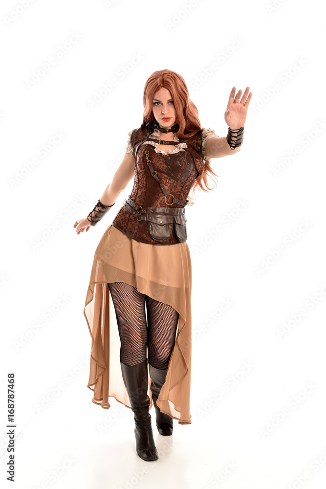 full length portrait of red haired lady wearing steampunk inspired outfit, standing pose against a white background.