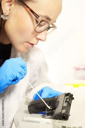 Criminologist lab technician working on forensic DNA analysis from handgun