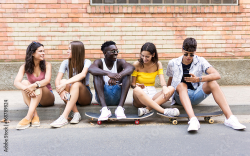Group of young hipster friends talking in an urban area.