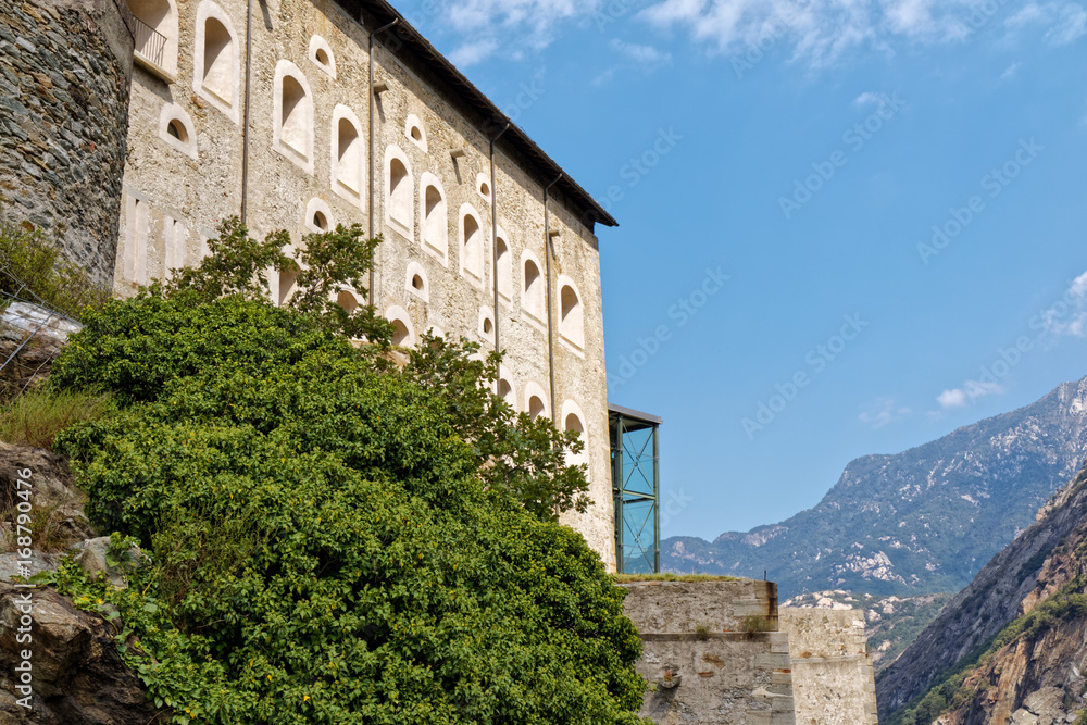 Fort Bard, Valle d'Aosta, Italy - August 18, 2017: Historic military construction defence Fort Bard. Touristic medieval fortress in Italian Alps. Location of the Avengers: Age of Ultron film. Fort Bard, Valle d'Aosta, Italy - August 18, 2017: Historic military construction defence Fort Bard. Touristic medieval fortress in Italian Alps. Location of the Avengers: Age of Ultron film.
