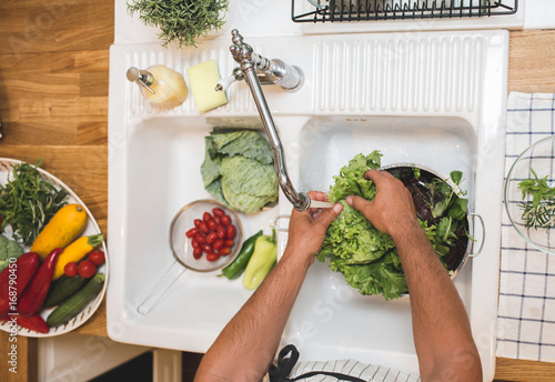 Man washes vegetables before eating photo