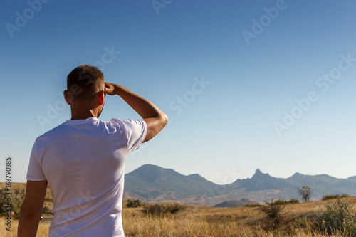 Fotografia, Obraz A man looking into the distance to the mountains