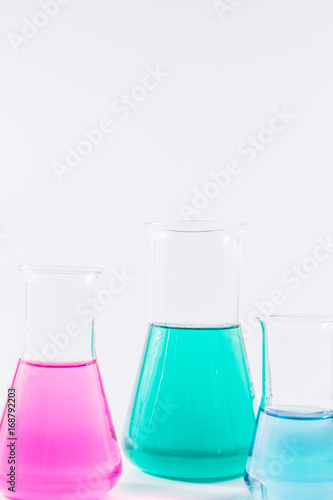  research, science and clinic background. 96 well micro plate and laboratory beakers with colorful liquids and reagents. 
