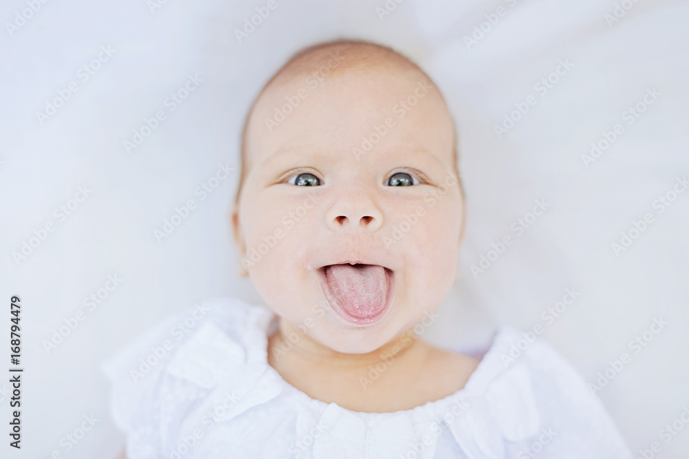 baby girl 3 month old child lying down on white blanket smiling happy fashion portrait face baby girl 3 month old child lying down on white blanket smiling happy fashion portrait face
