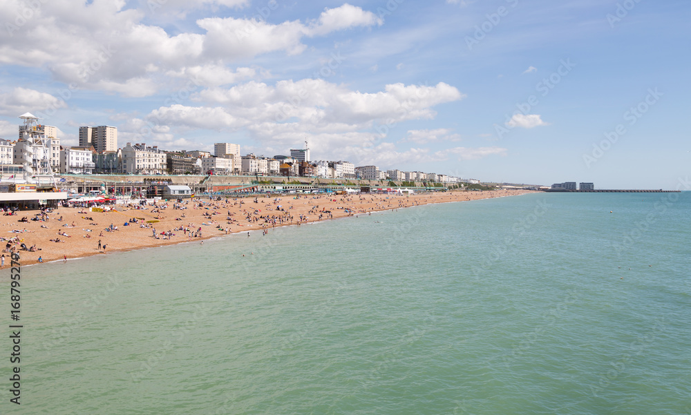 Brighton seafront and town with people enjoying the sunny beach