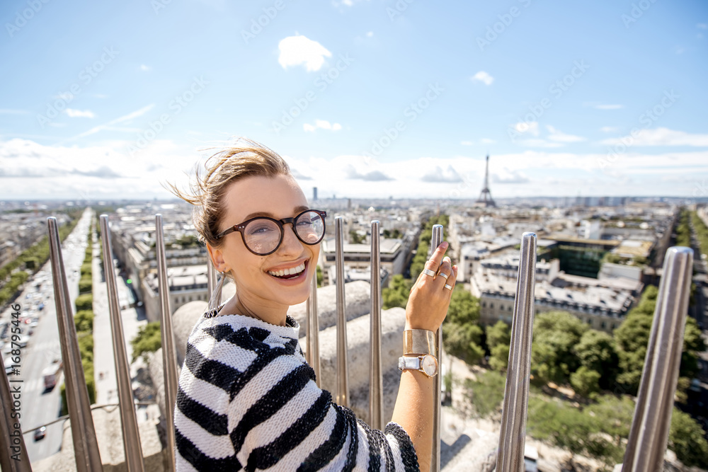 Young woman tourist enjoying great cityscape view on Paris during the sunny weather in France