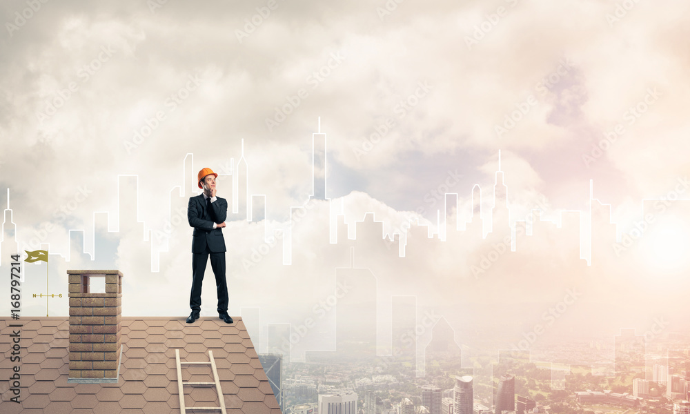 Engineer man standing on roof and looking away. Mixed media Engineer man standing on roof and looking away. Mixed media