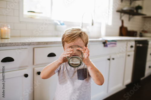 Boy drinking in kitchen photo