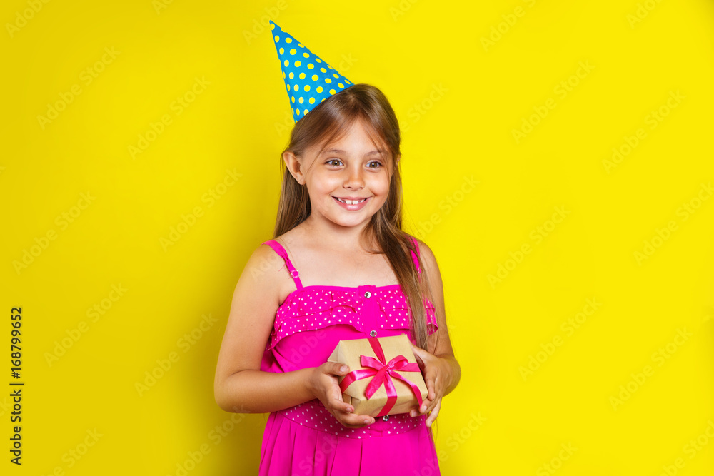 Studio portrait of a little girl wearing a party hat on her birthday. Cute girl open her birthday gift box Studio portrait of a little girl wearing a party hat on her birthday. Cute girl open her birthday gift box
