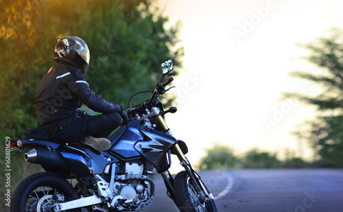 Motorcyclist sits on a motorcycle in a lotus pose.