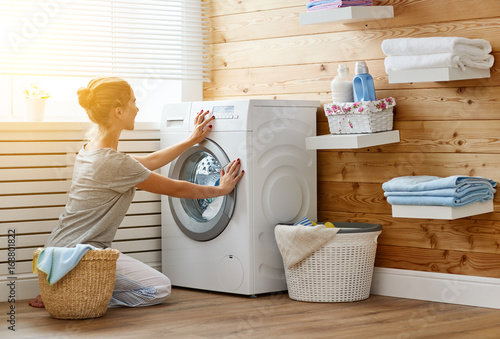 Konstfotografi Happy housewife woman in laundry room with washing machine
