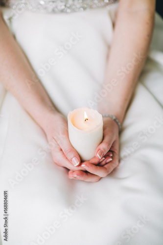 Wedding candle in hands of the bride