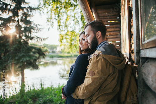 wife with husband sitting in canoe on coast of lake in sunny morning © VAKSMANV