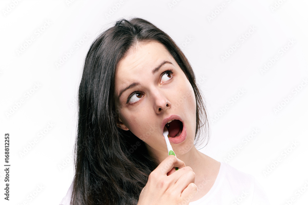 Beautiful young woman on white isolated background brushes teeth Beautiful young woman on white isolated background brushes teeth