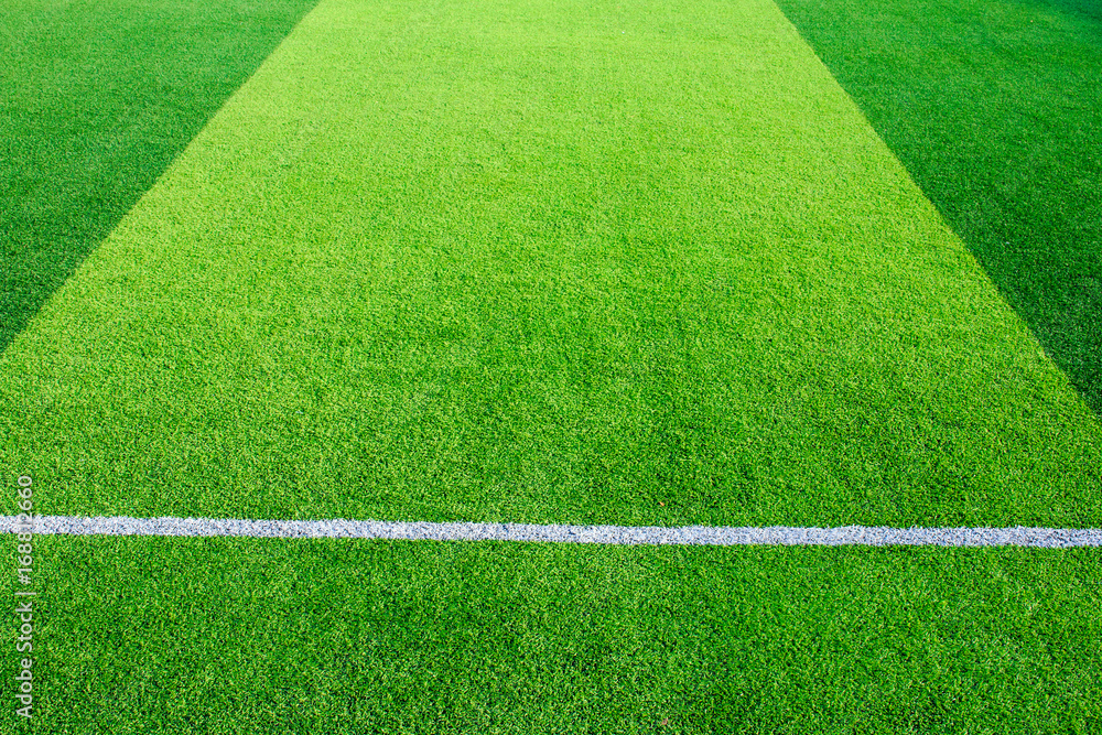 Obraz premium Photo of a green synthetic grass sports field with white line shot from above