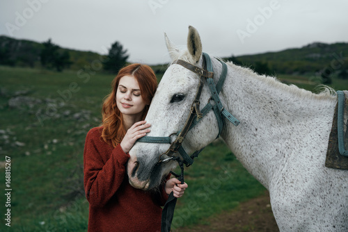 Beautiful young woman on nature walks with horse, in the mountains