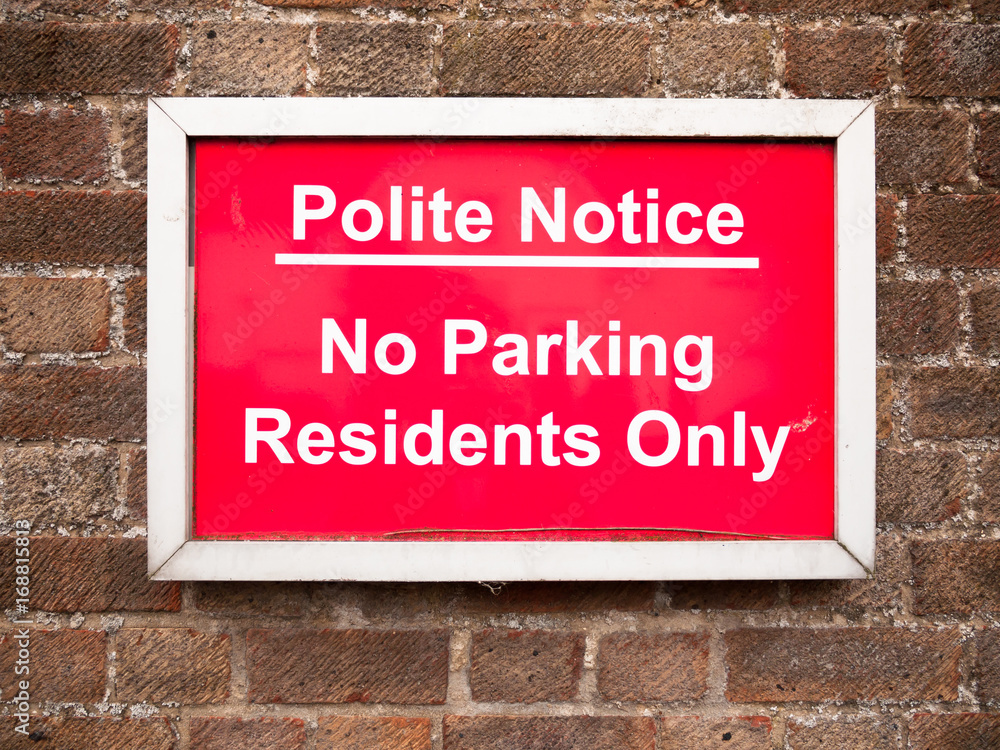 close up of red placard sign outside houses no parking residents only close up of red placard sign outside houses no parking residents only