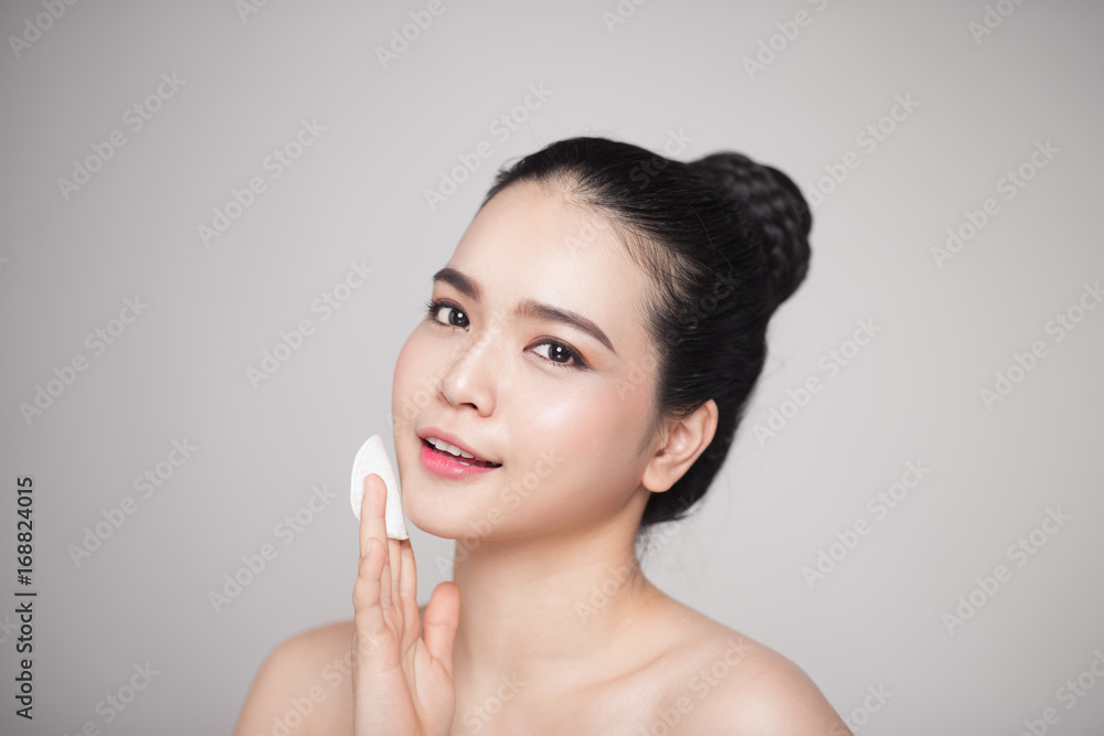 Happy smiling beautiful asian woman using cotton pad cleaning skin. Happy smiling beautiful asian woman using cotton pad cleaning skin.