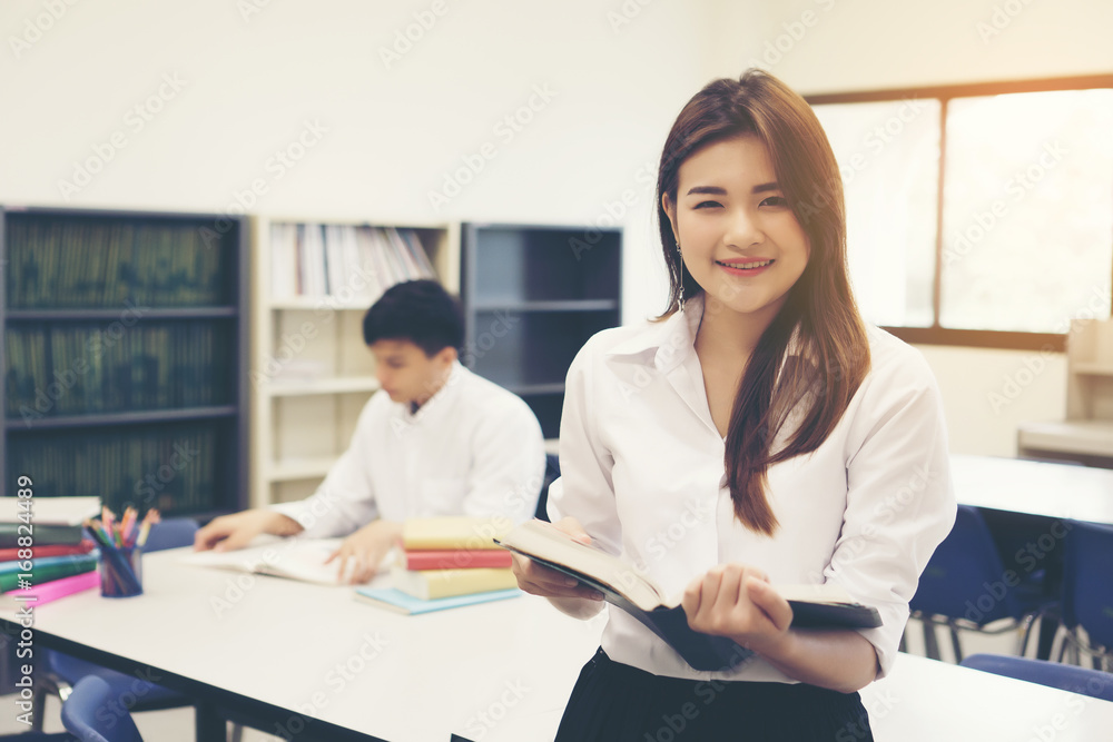 Young Asian students at the library reading a book. Education concept. Young Asian students at the library reading a book. Education concept.