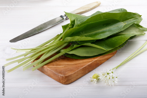 Wild garlic on white wooden table.