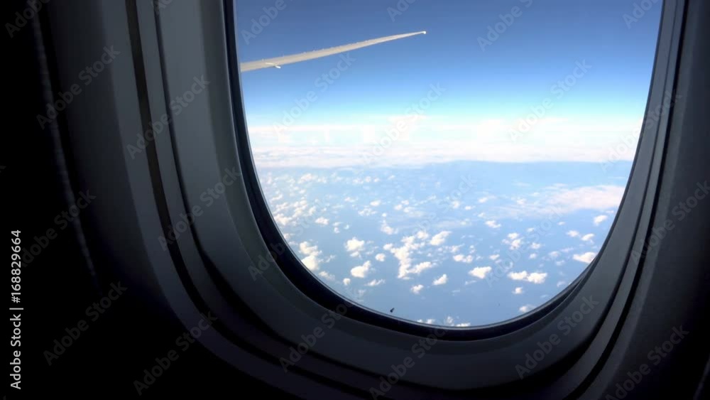View from airplane window to the sky and plane wing, nobody View from airplane window to the sky and plane wing, nobody