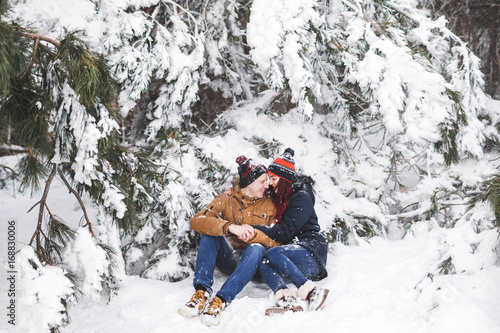 Сouple having fun and throwing snow in winter forest. A lot of snow around