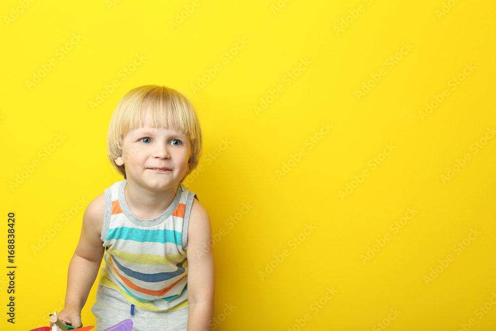 Naklejka premium Portrait of little boy on yellow background