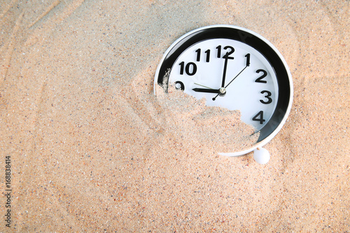 Black clock in beach sand photo