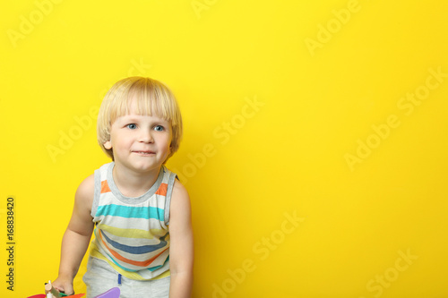 Portrait of little boy on yellow background