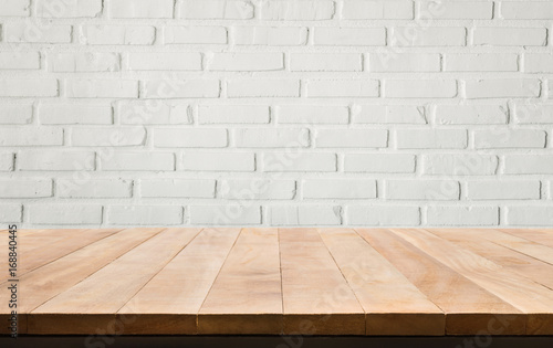 Empty wood table top with white brick wall background.